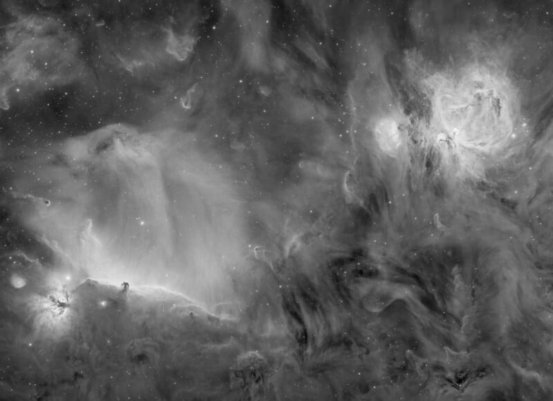 Black and white image of a nebula in space, filled with swirling clouds of gas and dust, bright stars scattered throughout, and areas of varying light intensity creating a dramatic, ethereal scene.