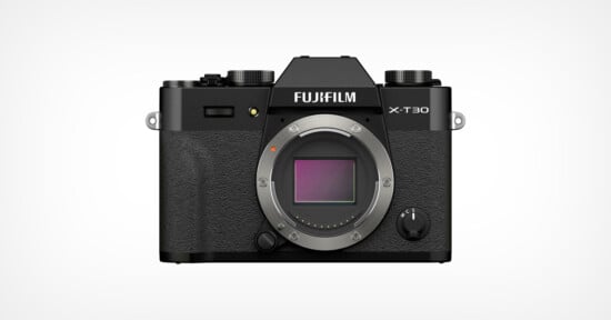 A Fujifilm X-T30 mirrorless camera body in black, shown from the front with the lens removed, revealing the camera sensor and textured grip. The brand and model name are visible above the sensor mount.