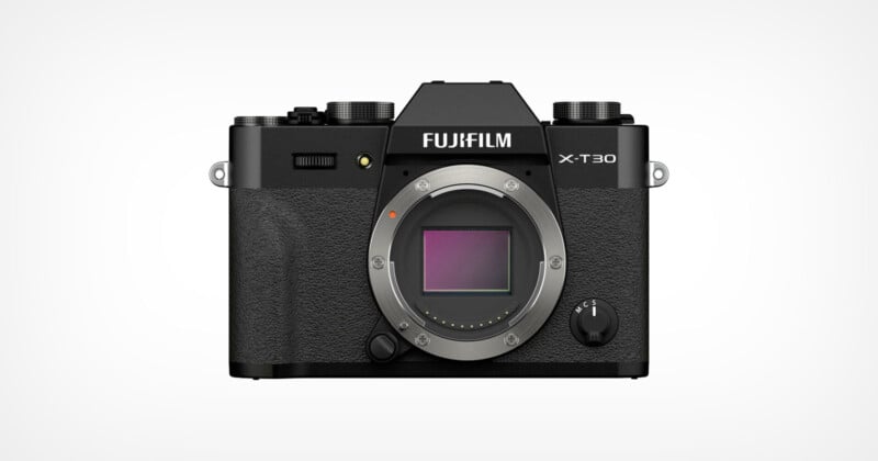 A Fujifilm X-T30 mirrorless camera body in black, shown from the front with the lens removed, revealing the camera sensor and textured grip. The brand and model name are visible above the sensor mount.
