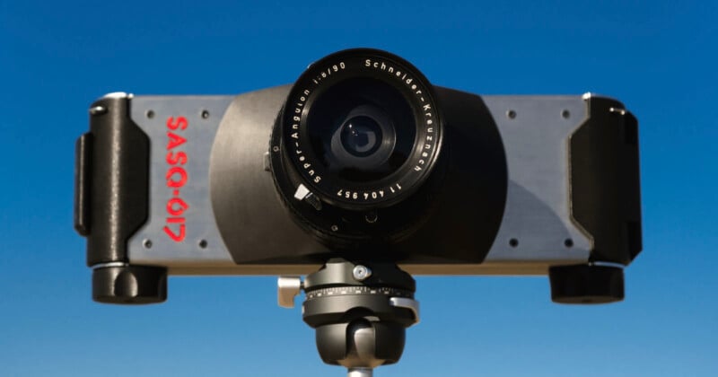Primer plano de la cámara panorámica SASQ-617 montada en un trípode con su lente gran angular hacia adelante hacia el cielo azul claro.