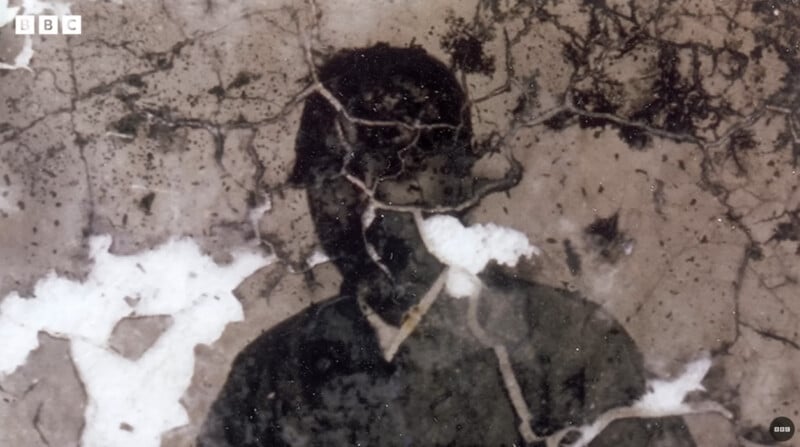 A damaged, weathered photograph of a person in dark clothing. The image is cracked and faded, making the person's facial features indistinct. BBC logo is visible in the top left corner.