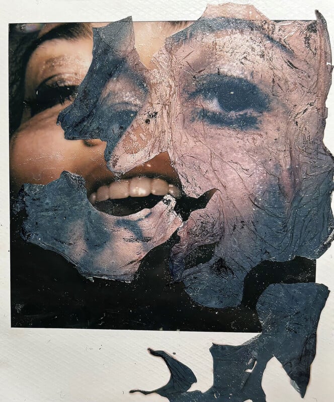 A partially obscured photo of a smiling person’s face, covered by irregular, peeling dark material that reveals only portions of the mouth, teeth, and one eye, creating a textured, layered effect.