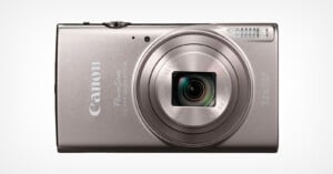 A silver Canon PowerShot digital camera with a retractable lens, flash, and 12x optical zoom, shown facing forward against a plain white background.