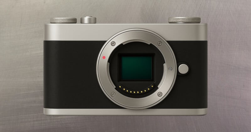 A digital camera body without a lens, featuring a silver and black design, is displayed against a brushed metal background. The camera’s sensor and lens mount are clearly visible.