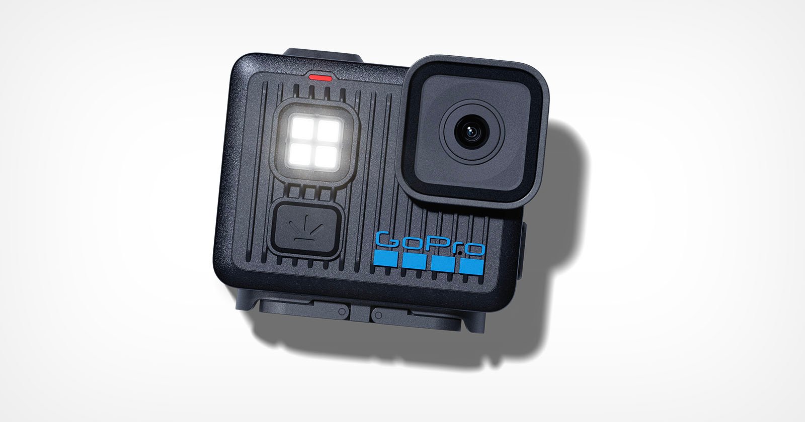 A black GoPro action camera with a prominent lens, built-in LED display, and blue GoPro logo is shown on a white background. The camera casts a soft shadow.