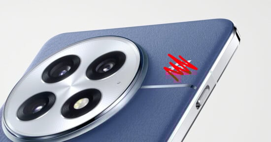 Close-up of a blue smartphone’s rear camera module, featuring three large camera lenses and a smaller sensor in a circular array. There is a red stylized logo or signature near the camera on the phone’s back.