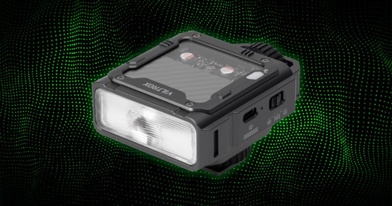 A compact, rectangular LED device labeled "VILTROX," shown against a black background with green dotted waves. The device has a translucent front light panel and visible buttons and ports on the sides.