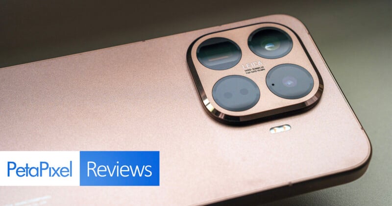 A close-up view of the rear camera module on a gold-colored smartphone, featuring multiple lenses and "Leica" branding. The bottom left corner displays the PetaPixel Reviews logo.