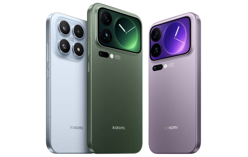 Three Xiaomi smartphones in silver, green, and purple are standing upright. Each phone features a large rear camera module with dual lenses and a flash, and the Xiaomi logo is visible at the bottom.