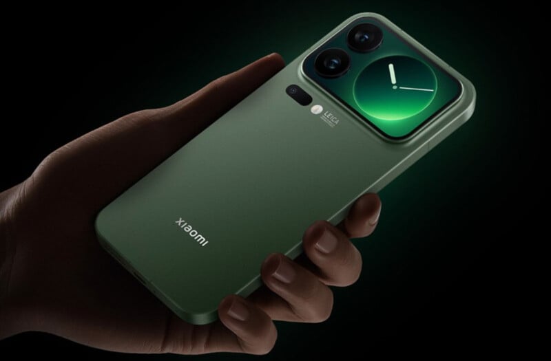 A hand holds a green Xiaomi smartphone with a large camera module featuring two lenses and a clock graphic on one lens. The phone is shown against a black background with a green glow.