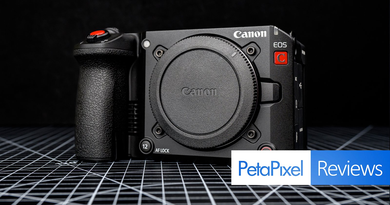 A Canon EOS cinema camera body without a lens is displayed on a grid-patterned surface with the Petapixel Reviews logo in the lower right corner.