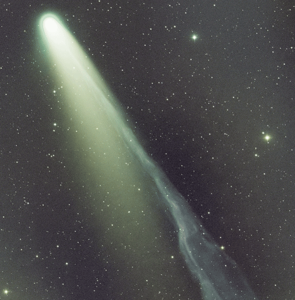 A bright comet with a glowing head and long, streaming tail travels through a star-filled night sky, leaving a luminous trail behind it.