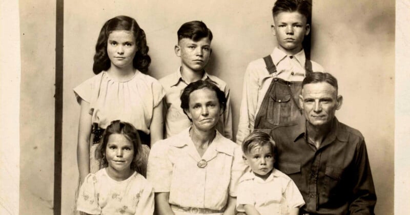 Un retrato en blanco y negro de principios del siglo XX de una familia que muestra a dos adultos y cuatro niños. Los adultos se sientan al frente y los niños se paran y se sientan alrededor de ellos, todos mirando a la cámara con rostros inexpresivos.