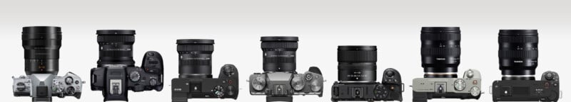 A row of seven digital cameras with various lenses, viewed from the front and top, showing different camera bodies and lens sizes against a light background.