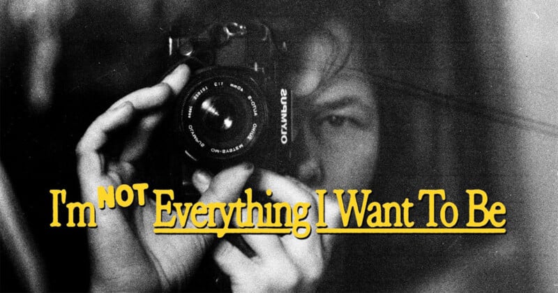 A person holds a camera close to their face, partially obscured in black and white. Yellow text over the image reads, "I'm NOT Everything I Want To Be.