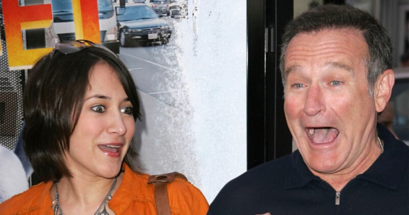 A woman and a man stand close together, both with surprised and animated facial expressions. The background features a movie poster with cars and bright colors.