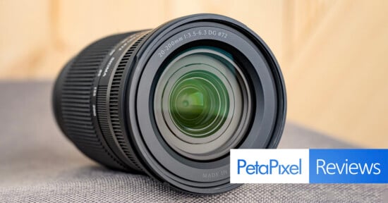 A close-up of a camera lens placed on a surface, with the "PetaPixel Reviews" logo in the bottom right corner.