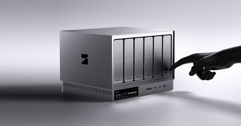 A sleek, modern external storage device with labeled drive bays. A hand is pointing toward one of the bays, which are labeled “MEDIA 1,” “MEDIA 2,” “PROJECTS,” and “BACKUP.” The device has a minimalist design.