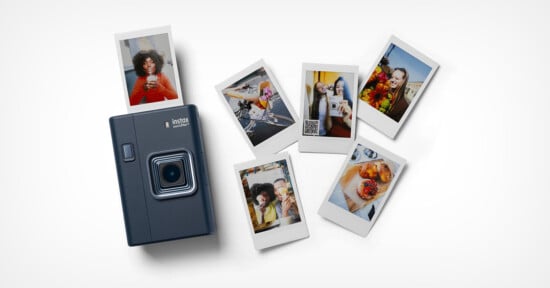A dark-colored instant camera is surrounded by six printed photos showing people posing, enjoying food, and having fun. The photos are spread out on a white surface.