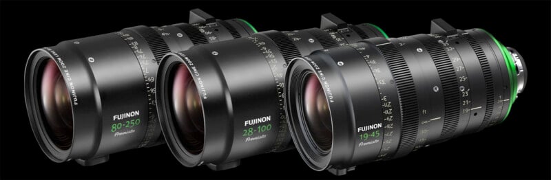 Three Fujinon Premista camera lenses are arranged diagonally on a black background. The lenses display focal lengths of 80-250mm, 28-100mm, and 19-45mm, with green accent rings near the lens mounts.
