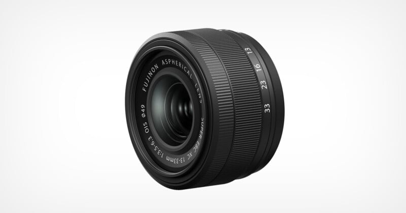 A Fujinon aspherical camera lens with a black, ribbed body, visible focus, and aperture rings, marked with various focal lengths and aperture values. The lens is positioned against a plain white background.