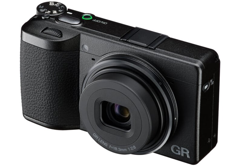 A black compact digital camera with a textured grip, extended lens, various control buttons, and the "GR" logo on the front.