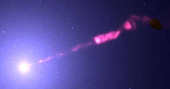 A bright celestial object emits a glowing pink jet of light extending diagonally through space, surrounded by faint stars against a dark background.