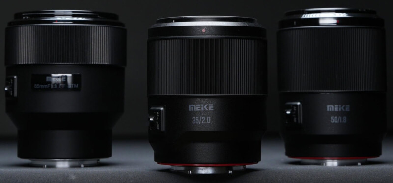 Tres lentes de cámara Meike se muestran en posición vertical sobre un fondo oscuro. Los tamaños de lente visibles son 85 mm f/1.8, 35 mm f/2.0 y 50 mm f/1.8 y lentes de 35 mm en el primer plano central.