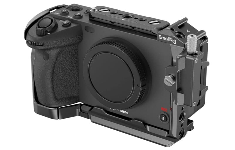 A black digital camera encased in a metal SmallRig cage, featuring various mounting points, a textured grip on the left, and multiple buttons and dials on the body.