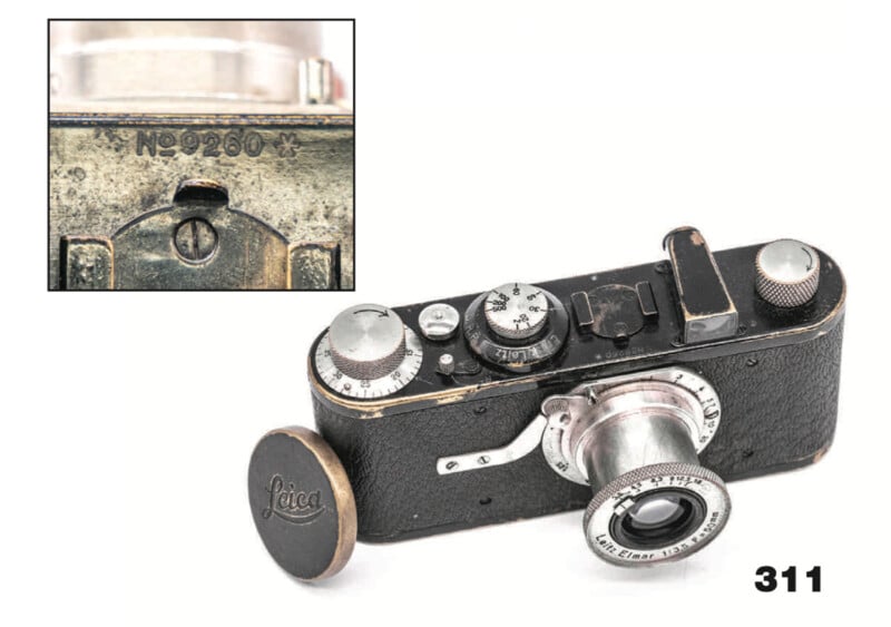 A vintage Leica camera with a removable lens and a worn black body. An inset shows a close-up of the serial number "No 9260." The number “311” is printed in bold in the bottom right corner.