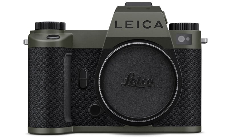Front view of a Leica camera in olive green and black, with a textured grip and no lens attached. The Leica logo is visible above the lens mount and on the body cap.