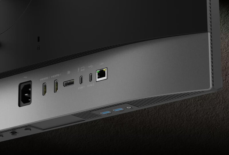 Un primer plano del panel posterior del monitor, que muestra los distintos puertos, incluida la alimentación, dos HDMI, un DisplayPort, USB-C, LAN (Ethernet), dos USB-A y un conector para auriculares.