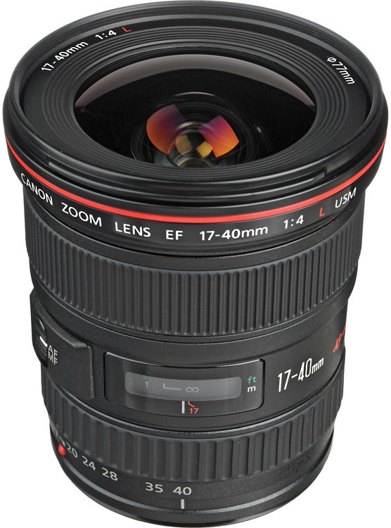 A Canon 17-40mm f/4L USM zoom lens with a red ring, zoom and focus rings, and lens markings is shown standing upright on a white background.