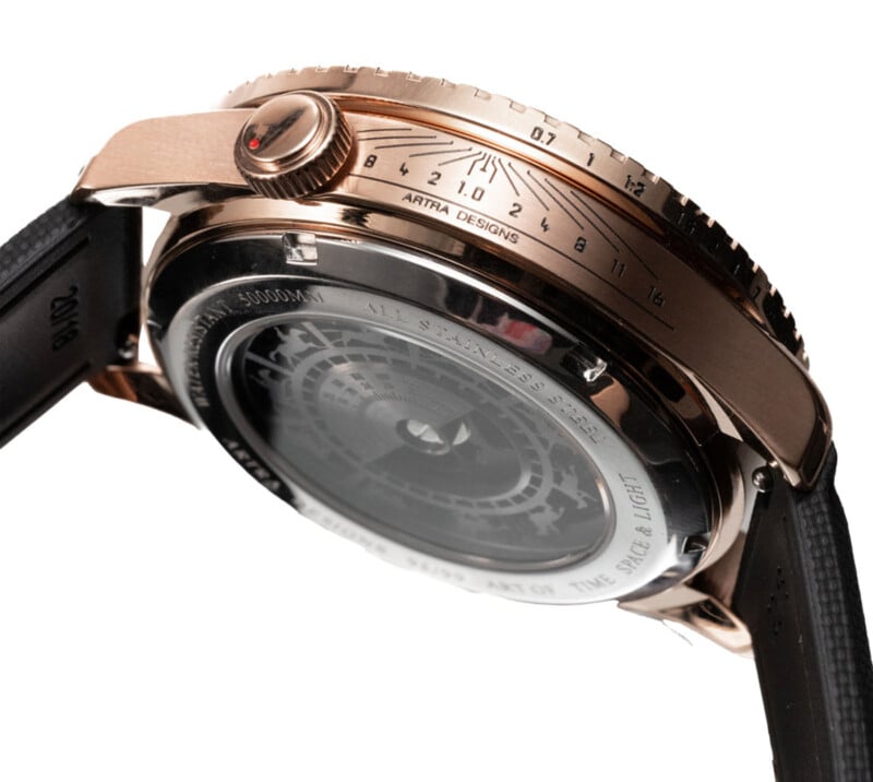 Vista lateral de un reloj de lujo con caja de oro rosa, correa negra y un diseño de esfera único que muestra intrincadas marcas marcadas 