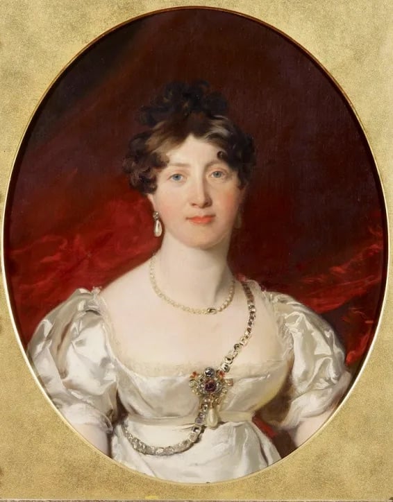 A classical oil portrait of a woman with dark curly hair, wearing pearl earrings, a white dress with puffed sleeves, and a jeweled chain across her chest, set against a dark red background in an oval frame.