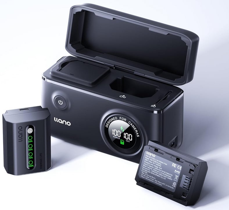 A black llano battery charger with its lid open, showing two battery slots, a digital display, and power button. Two rectangular camera batteries are placed in front of the charger.