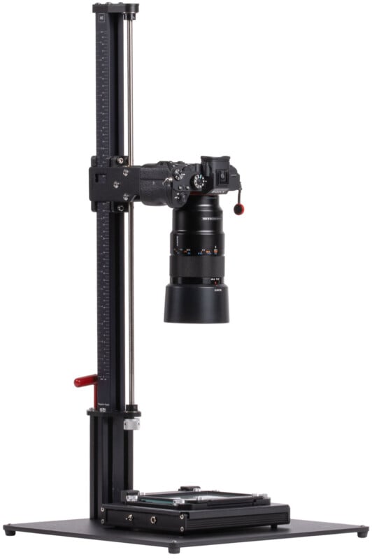 A professional camera is mounted on a vertical copy stand with a measurement scale, adjustable height, and a flat base designed for photographing documents or flat objects.