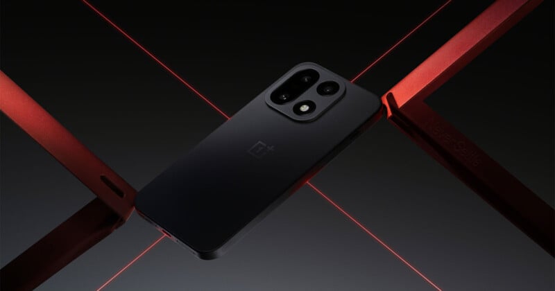 Un elegante teléfono inteligente negro con cámaras traseras duales yace reclinado sobre una superficie oscura, con barras rojas metálicas y líneas láser rojas que se cruzan para crear una composición futurista y elegante.