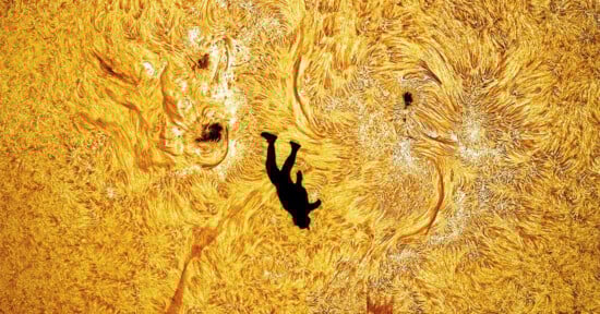 A silhouette of a person appears to fall or float against a vibrant, swirling yellow and orange background resembling the surface of the sun.