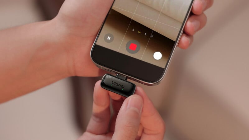 Una persona conecta un micrófono Wulanzi a un teléfono inteligente y se prepara para grabar un video, cuando se abre la aplicación de la cámara del teléfono.