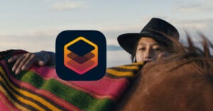 A person in a black hat stands behind a horse covered with a colorful blanket. An abstract app icon with red and orange layers is overlaid in the center of the image, partially covering the person's face.