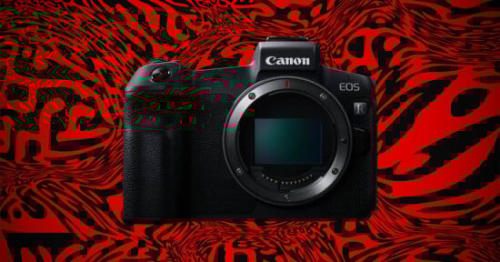 A Canon EOS R mirrorless camera is displayed against a bold red and black abstract patterned background. The camera’s lens mount is exposed, and the Canon logo is visible on top.