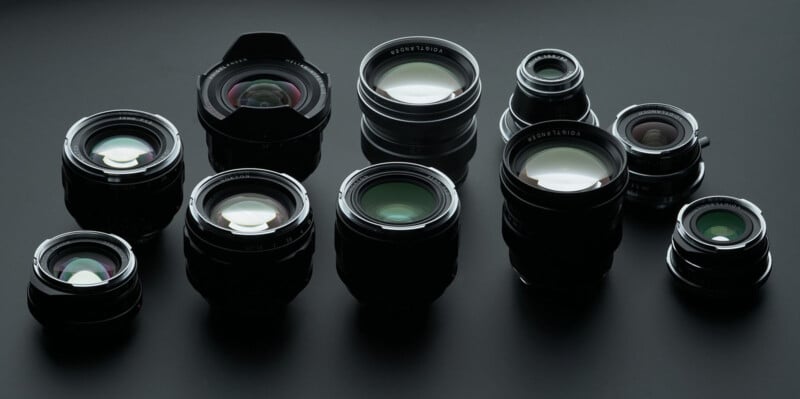 Una colección de nueve lentes de cámara de diferentes tamaños y diseños, dispuestas sobre una superficie oscura, reflejando la luz sobre elementos de vidrio.