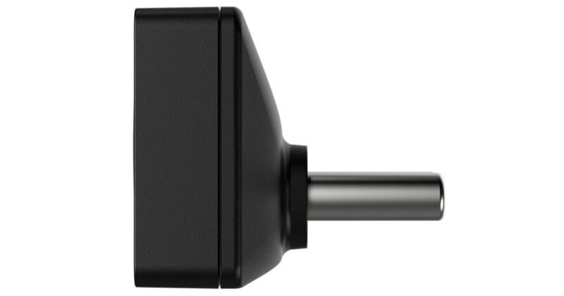 Un enchufe adaptador de corriente CC rectangular negro que se muestra desde un lado, mostrando el conector metálico cilíndrico que se extiende hacia afuera.