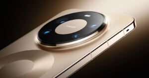 A close-up view of a gold smartphone showing its large, circular rear camera module with multiple lenses and a rectangular flash on a metallic surface.