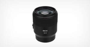 A black Meike 85mm f/1.8 camera lens is shown upright on a plain white background, with the brand name and lens specifications visible on the front of the barrel.