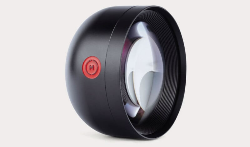 Primer plano de un accesorio de lente de cámara negro con un botón redondo rojo prominente con el logotipo 