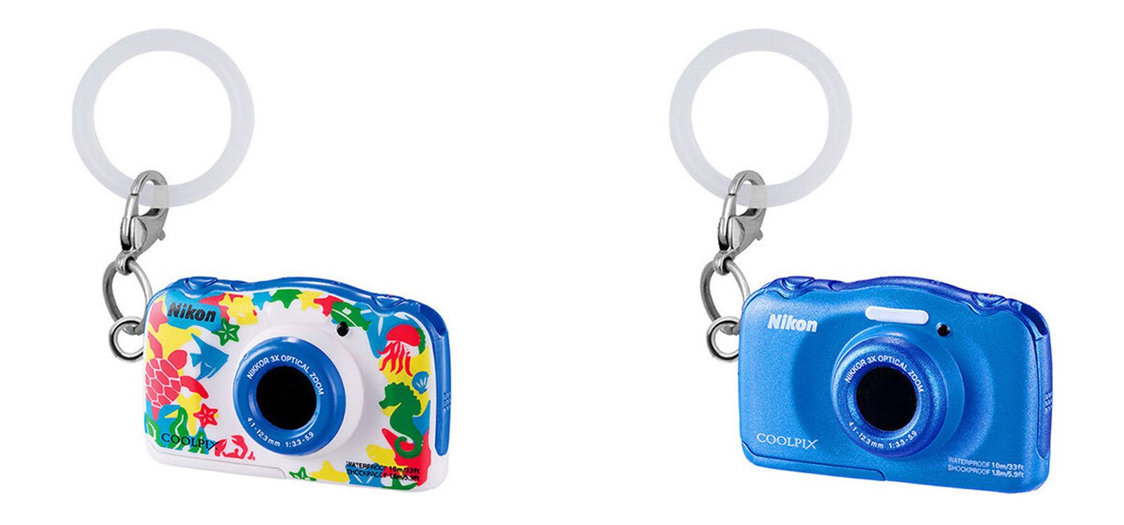 Two Nikon camera keychains are shown side by side. The left keychain is decorated with colorful sea creatures, while the right one is solid blue. Both have a round, clear key ring attached.