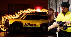 A yellow Nikon-branded SUV with flames on its roof is parked at night. Next to it, a woman and a man in a bright yellow shirt examine a camera together outdoors during the day.