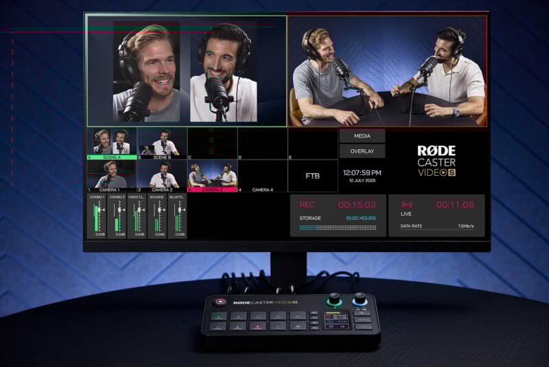 A computer monitor displays a video podcast recording with two men speaking into microphones, wearing headphones. Video editing software shows various camera angles, audio levels, and controls. A control panel sits in front of the monitor.